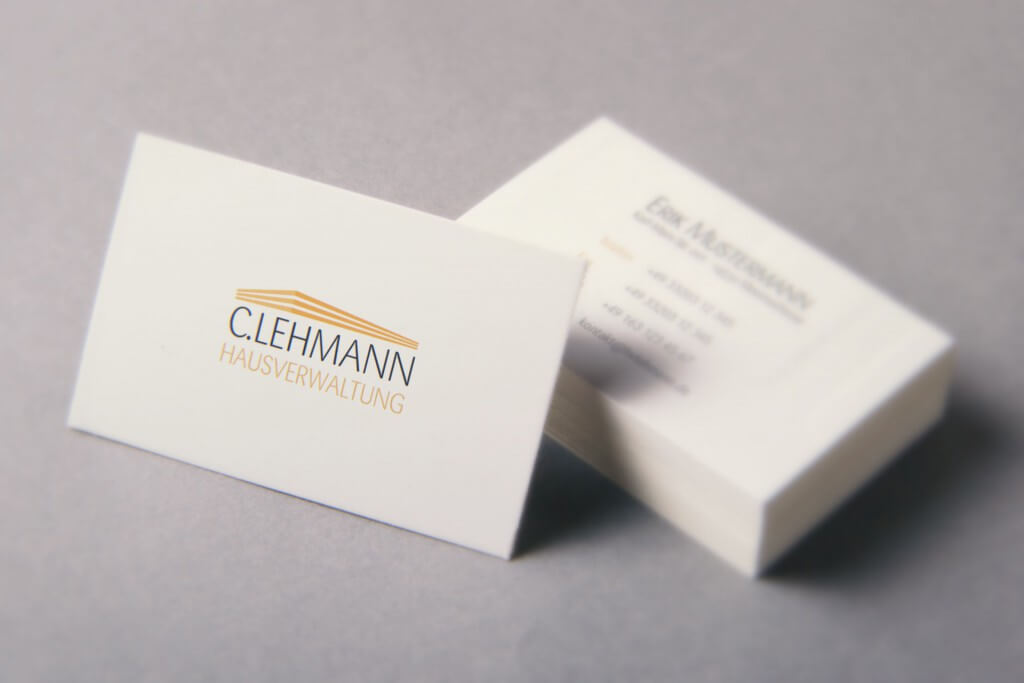 Visitenkarten mit Logo der C. Lehmann Hausverwaltung und goldenem Dach-Symbol